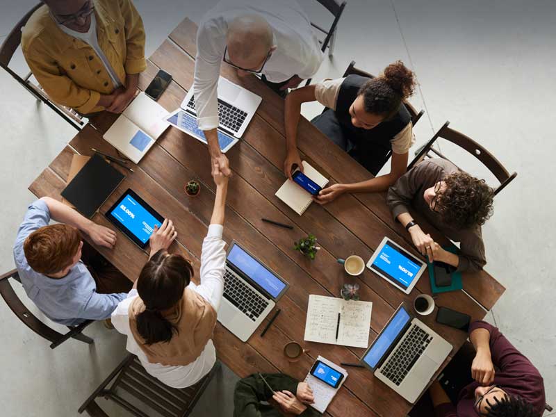 FELS Group Stellenausschreibungen - mehrere Personen sitzen am Besprechungstisch und treffen Vereinbarungen