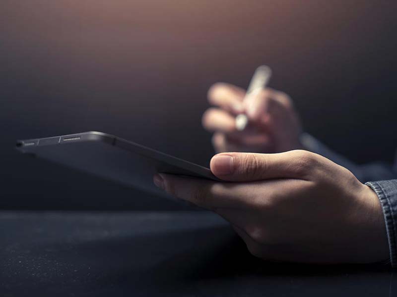 FollowMyMoney Geldanlage mit den Besten FAQ - Person schreibt auf einem Tablet in der Hand